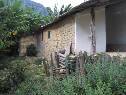 Il retro della casa mostra le mura fatte di fango e legno.