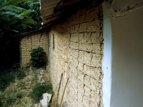 Il retro della casa mostra le mura fatte di fango e legno.