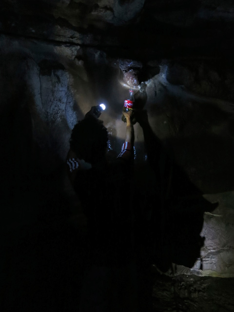 Jorge riempie le bottiglie di acqua in una sorgente nella grotta.